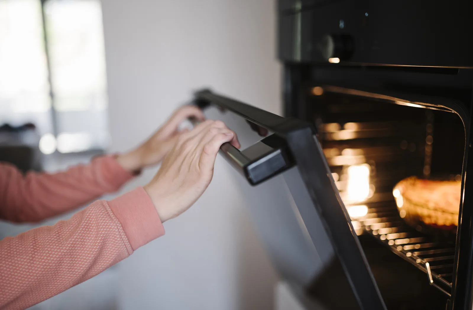 Oven door and interior being carefully wiped clean